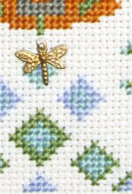 detail of cross stitch Fountain sampler kit with brass charm
